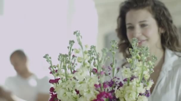Женщина расставляет вазу с цветами — стоковое видео