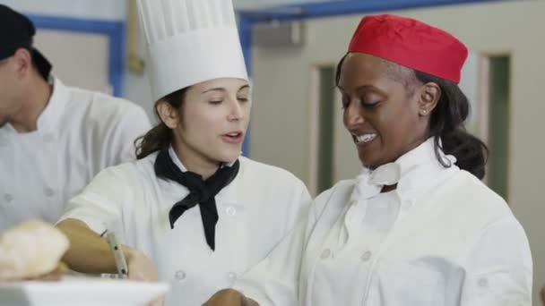 Equipe feliz de chefs em uma cozinha comercial, trabalhando e conversando juntos — Vídeo de Stock