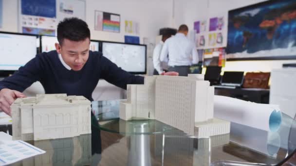 Jonge Aziatische architect of ingenieur kijken naar concept modellen van nieuwe ontwikkeling — Stockvideo
