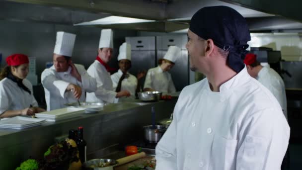 Portret van een jonge stagiair chef-kok of een werknemer in een commerciële keuken — Stockvideo