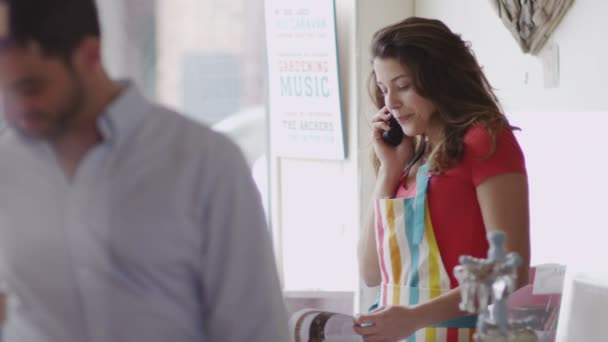 Butiksägaren gör telefonsamtal på jobbet — Stockvideo