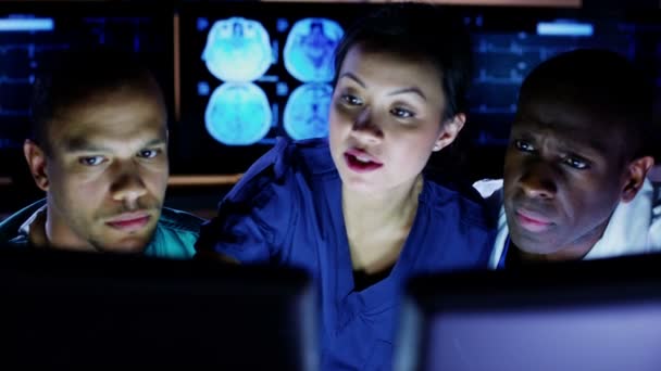 Equipe médica trabalhando até tarde em um computador e discutindo o que eles vêem na tela — Vídeo de Stock