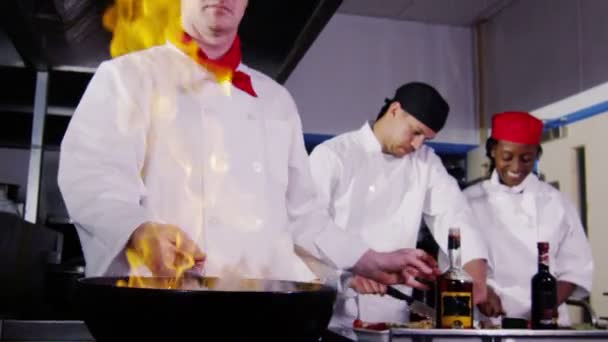 Professionele chef-kok in een commerciële keuken koken flamberen stijl. — Stockvideo