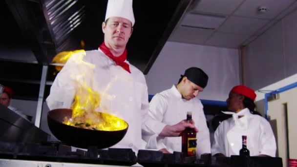 Professionell kock i kommersiella kök matlagning flambe stil. — Stockvideo