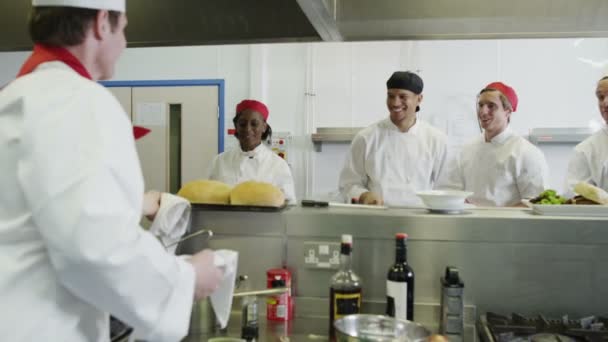 Зрілий чоловічий шеф-кухар тримає лоток свіжоспеченого хліба — стокове відео