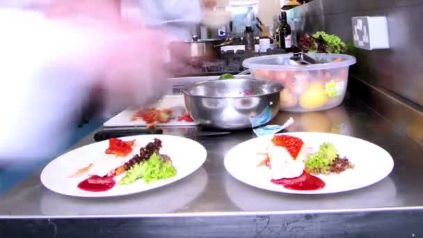 Equipo ocupado de chefs preparando comida en una cocina comercial — Vídeos de Stock