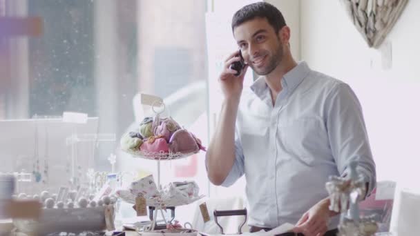 Winkeleigenaar maakt telefoongesprek op het werk — Stockvideo