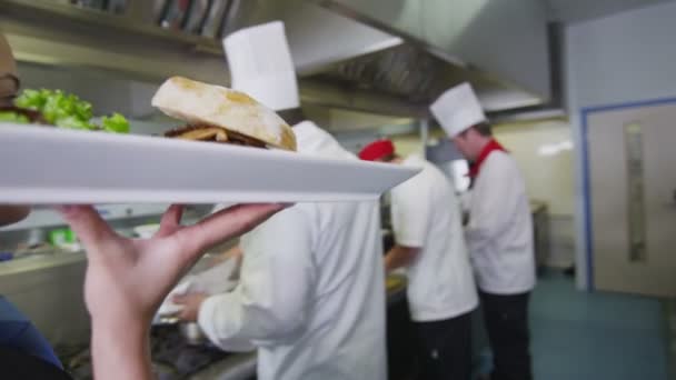 Deliciosa hamburguesa gourmet es preparado por el chef y llevado por la camarera — Vídeos de Stock