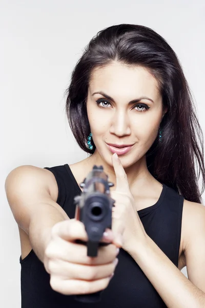 Young woman holding a gun saying shh — Stock Photo, Image
