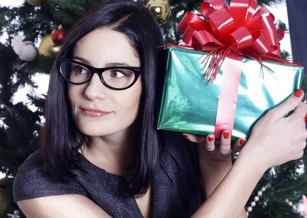 Hübsche Geschäftsfrau neben Weihnachtsbaum mit Geschenk — Stockfoto