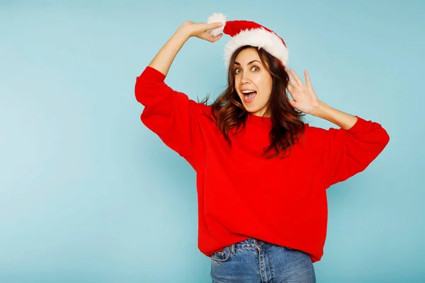 年轻的美国妇女头戴并手持圣诞红帽 近在眼前 震惊而惊讶 圣诞及新年新闻概念 — 图库照片