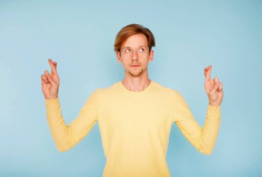 Genç düşünceli şanslı adam parmaklarını bir arada tutar, iyi şans konsepti, bir konsept için umut