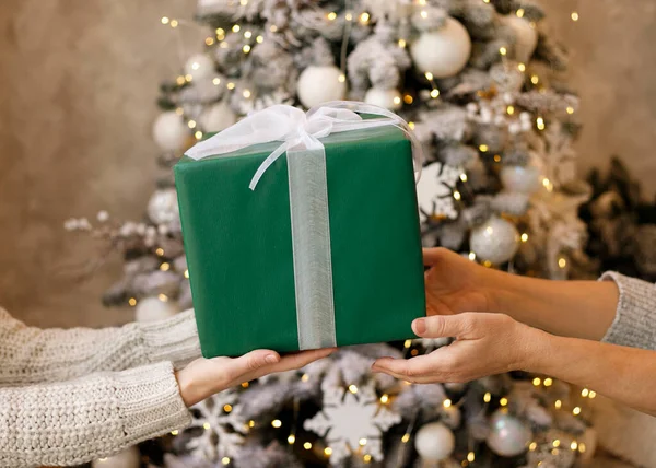 Nahaufnahme Von Kind Und Mutter Hände Mit Geschenkbox Über Weihnachtsbaumbeleuchtung — Stockfoto