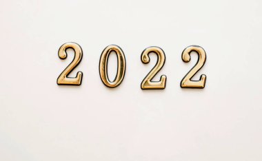 Yeni yıl ve yeni yıl beyaz arka planı altın sayılar 2022. Yeni yıl kart dekorasyonu kavramı, metin için yeri olan üst görünüm.