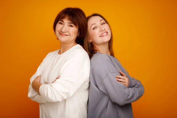 Mutter Und Tochter Lächeln Glücklich Vor Isoliertem Gelben Hintergrund Muttertagsferienkonzept Stockbild