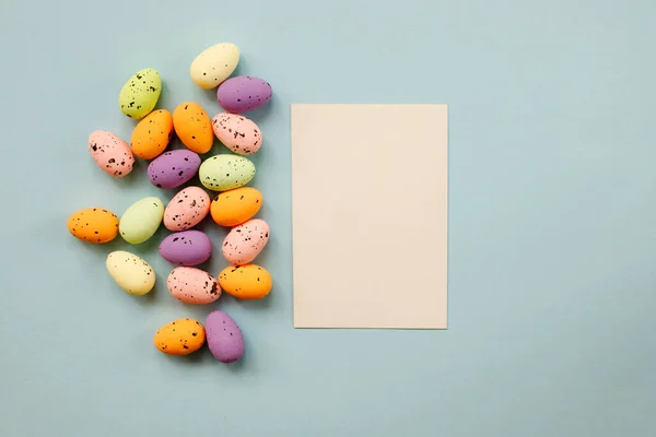 Frohe Osterkomposition Mit Ostereiern Und Papierrohling Auf Pastellblauem Hintergrund Flache Stockbild