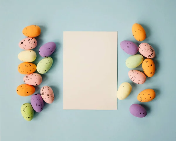 Frohe Osterkomposition Mit Ostereiern Und Papierrohling Auf Pastellblauem Hintergrund Flache Stockfoto