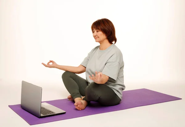 Yılların Güzel Fotojenik Kadını Yoga Yapıyor Stüdyoda Dizüstü Bilgisayarın Önünde — Stok fotoğraf