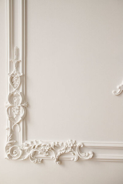 Decorative clay stucco relief molding with ornaments on white ceiling in abstract classical style interior