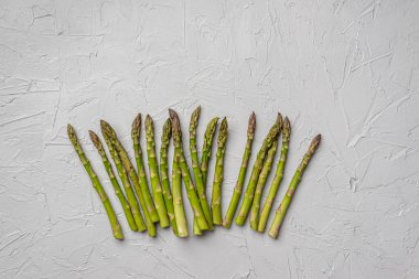 Gevşek yeşil kuşkonmaz gri bir arka planda yatıyor