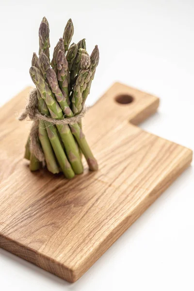 White Background Bunch Fresh Green Asparagus Stands Kitchen Board Vertical — Foto de Stock