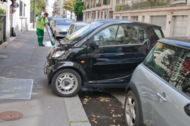 Paris - 14 Temmuz: kimliği belirsiz bir adam yanında kaldırım süpürme arabalar Park paris, 14 Temmuz 2011.