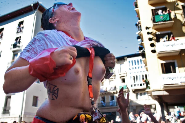 Pamplona, spanien - 6. juli: eine frau oben ohne tränkt rotwein bei o — Stockfoto