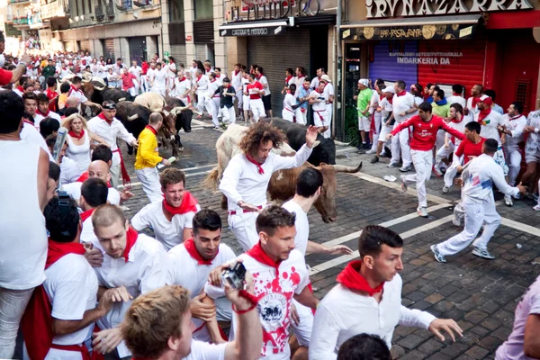PAMPLONA, SPAIN -JULY 8: Unidentified men run from bulls in stre — Stock Photo, Image