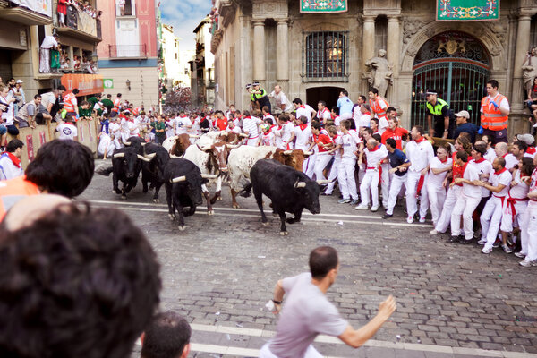 PAMPLONA, SPAIN-JULY 9: Bulls and people are running in street d