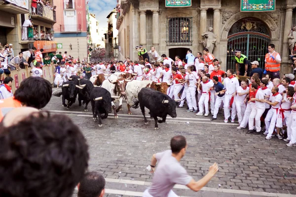 PAMPLONA, ESPAÑA 9 DE JULIO: Toros y gente corriendo en la calle d Imagen de archivo