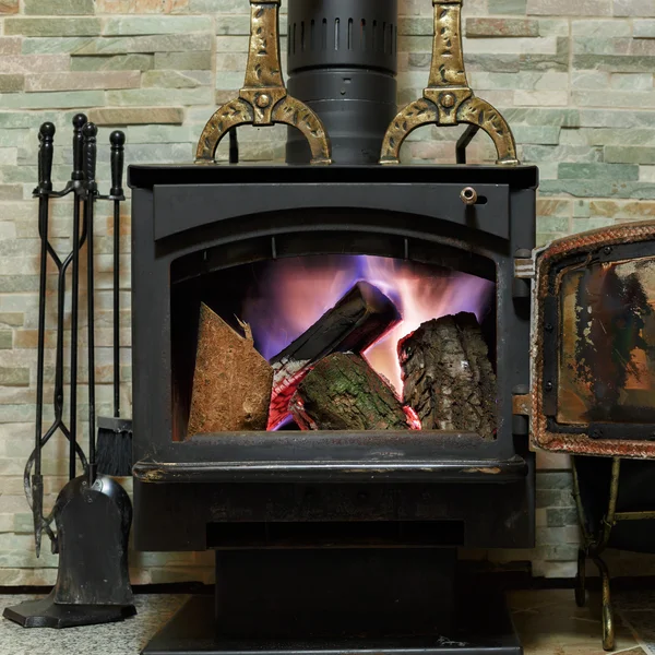 Alte Feuerstelle mit brennendem Feuerholz — Stockfoto