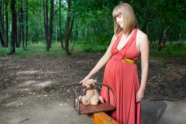 Красивая беременная женщина в солнечном парке — стоковое фото