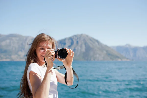 Turista tomando una fotografía al lado del mar — Foto de Stock