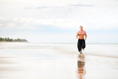 fiziksel olarak uygun sahilde koşan adam