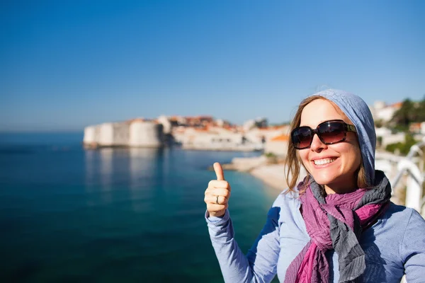 Femeia turistică împotriva orașului vechi Dubrovnik dând degetele mari — Fotografie, imagine de stoc