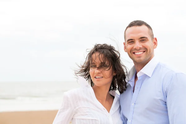 Smiling young couple at beautiful summer beach — Stock Photo, Image