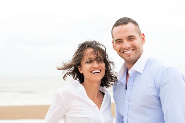 Smiling young couple at beautiful summer beach — Stock Photo, Image