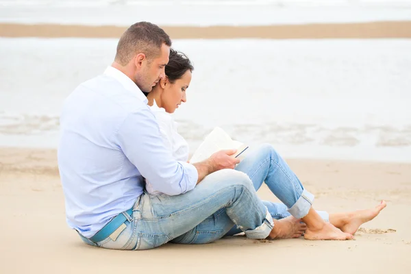 Casal leitura livro na praia — Fotografia de Stock