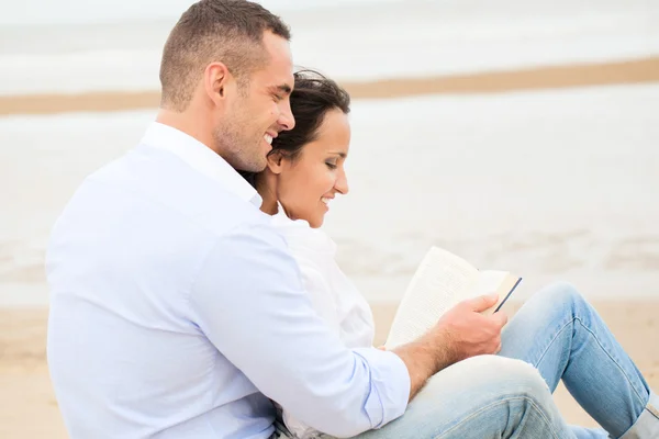 Livre de lecture couple sur la plage — Photo