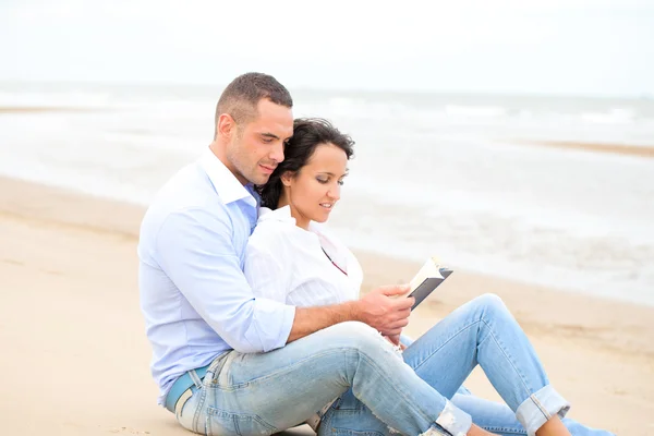 Casal leitura livro na praia — Fotografia de Stock