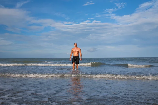 Retrato de joven fuerte en la playa — Foto de Stock