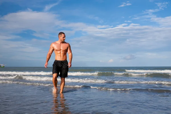 Portrét silný mladý muž na pláži — Stock fotografie