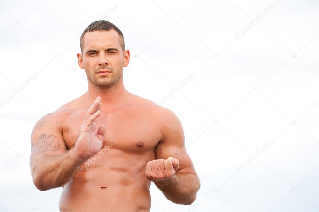 Young handsome muscular man at the sea