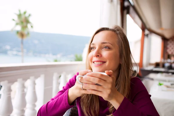 Mulher em um restaurante está bebendo café — Fotografia de Stock