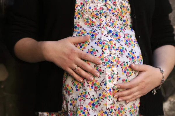 Donna incinta in camicetta colorata che abbraccia lo stomaco — Foto Stock