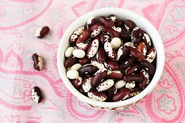 One bowl with red and white beans on pink tablecloth — Stock Photo, Image