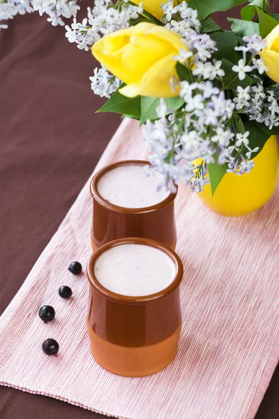 Hausgemachter Joghurt mit Beeren und einem Strauß Frühlingsblumen — Stockfoto