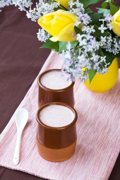 Yogur casero con bayas y un ramo de flores de primavera — Foto de Stock