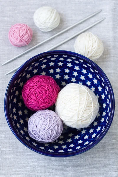 Bright balls of yarn and knitting needles on a plate — Stock Photo, Image