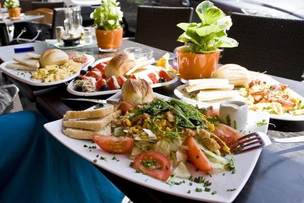 Ein leckeres und herzhaftes Frühstück an einem Straßencafé-Tisch lizenzfreie Stockbilder